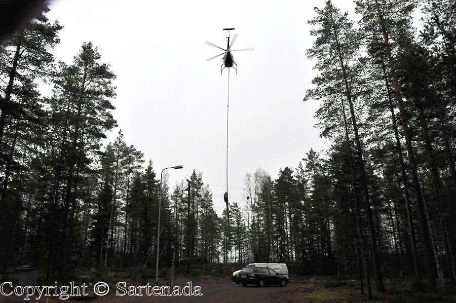 Helicopter cutting branches from electric lines